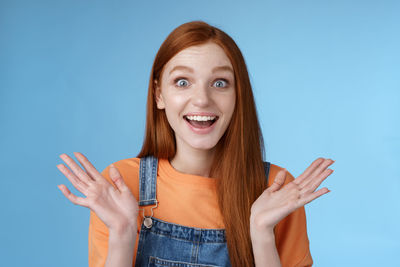 Excited young woman against blue background