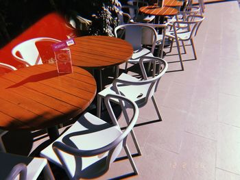 High angle view of empty chairs and tables at sidewalk cafe