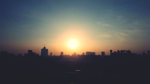 Silhouette buildings against sky during sunset