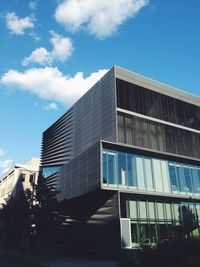 Low angle view of modern building against blue sky