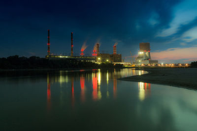 Reflection of smoke stacks on river at dusk