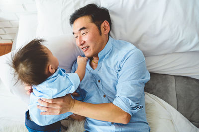 Father and son on bed at home