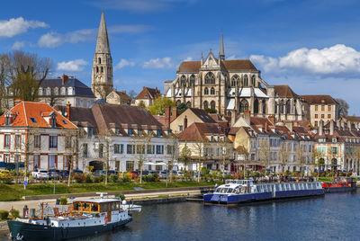 Boats in river against buildings in city