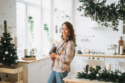 Portrait of smiling woman standing at home