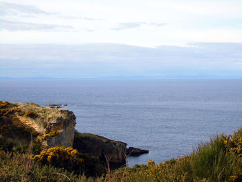 Scenic view of calm sea against cloudy sky