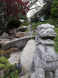 Statue on rock against trees