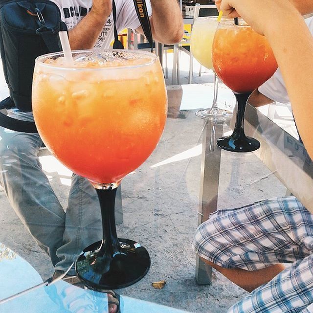 food and drink, drink, table, refreshment, freshness, lifestyles, food, restaurant, orange color, men, healthy eating, holding, drinking glass, person, incidental people, part of, close-up