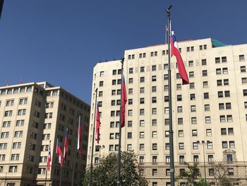 Low angle view of flag against buildings in city