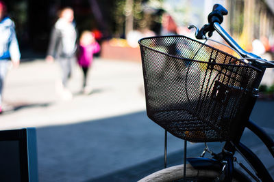 Close-up of bicycle in basket on table by street