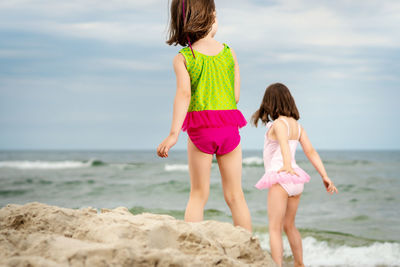 Rear view of siblings standing at beach