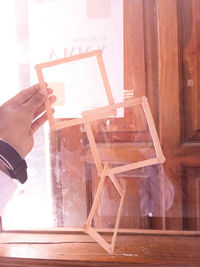 Midsection of man holding table by window