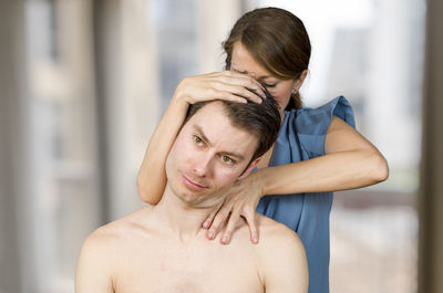 Female masseur massaging man in spa