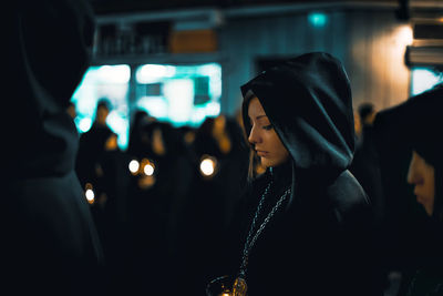 Midsection of woman looking at illuminated nightclub