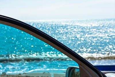 View of sea against sky seen through car windshield