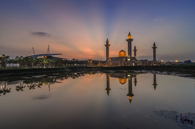 Reflection of tengku ampuan jemaah mosque in lake against sky during sunrise
