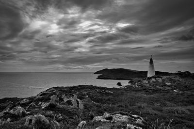 Lighthouse by sea against sky