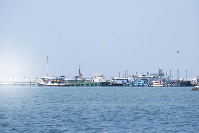 Commercial dock by sea against clear sky