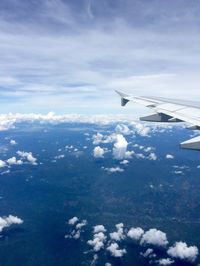 Aerial view of airplane wing over clouds