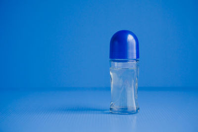 Close-up of glass bottle against blue background