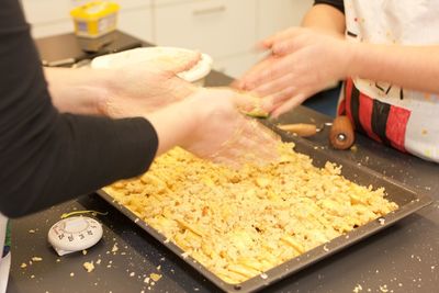 Midsection of children preparing food in kitchen