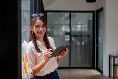 Portrait of smiling woman holding mobile phone