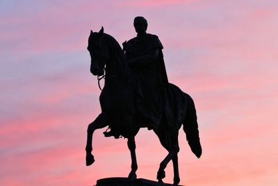 Silhouette of man riding horse