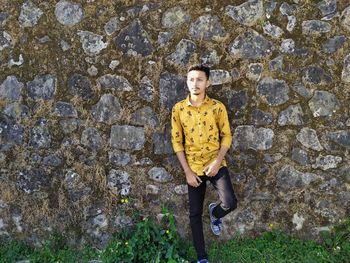 Thoughtful man standing against wall