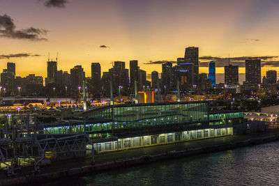 Illuminated cityscape against sky during sunset