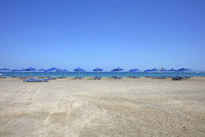 Scenic view of beach against clear blue sky