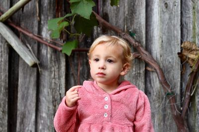 Cute girl looking away while standing outdoors