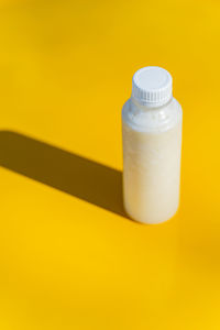 Close-up of bottle against yellow background