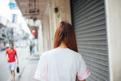 Rear view of woman standing in city