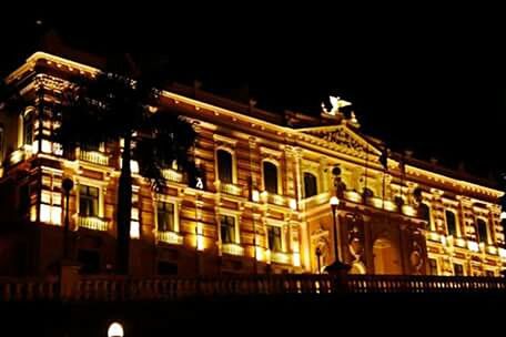 LOW ANGLE VIEW OF ILLUMINATED BUILDING AT NIGHT