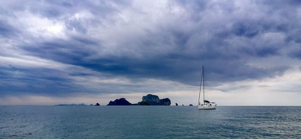 Sailboats in sea against sky