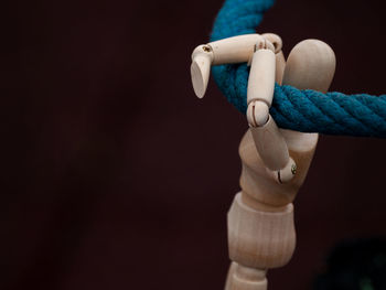 Close-up of wooden figurine hanging on rope
