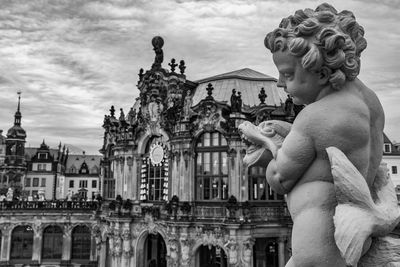 Statue of historic building against cloudy sky