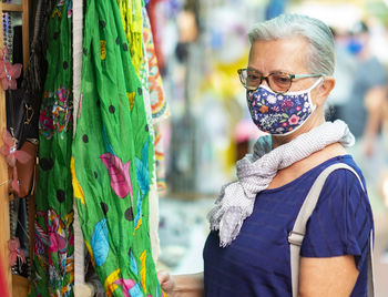 Senior woman wearing mask standing at market