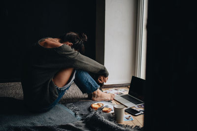 Side view of man using mobile phone at home