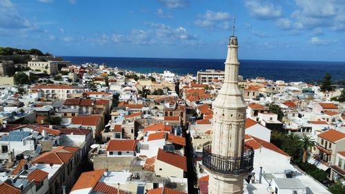 High angle view of townscape by sea against sky