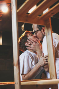 Couple kissing while standing by rack