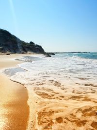 Scenic view of beach against clear blue sky