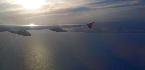 Airplane flying over sea against sky