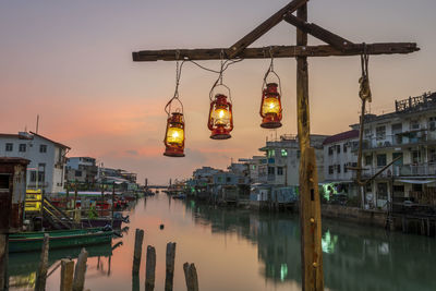 Reflection of illuminated buildings in water at sunset