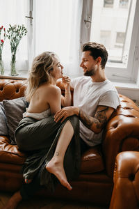 Young couple sitting on sofa at home