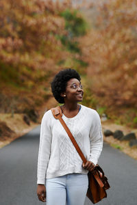Smiling woman standing outdoors during autumn