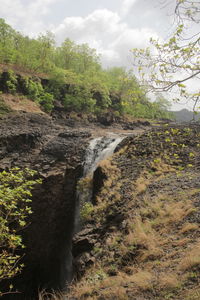 Scenic view of waterfall against sky