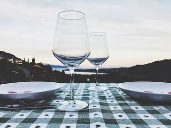 Close-up of wineglass on table against sky