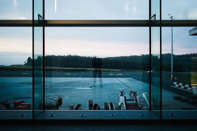 Man reflecting on glass at airport