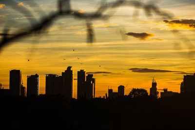 Silhouette buildings against sky during sunset