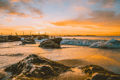 Scenic view of beach against sky during sunset